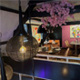 Restaurant interieur met roze muur, kunstwerken, bloesemdecoratie en elegant gedekte tafels
